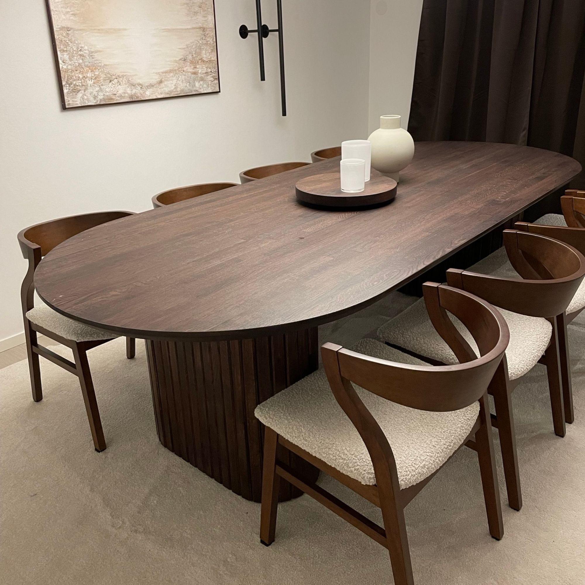 Ovalt spisebord i brun farge og brune stoler